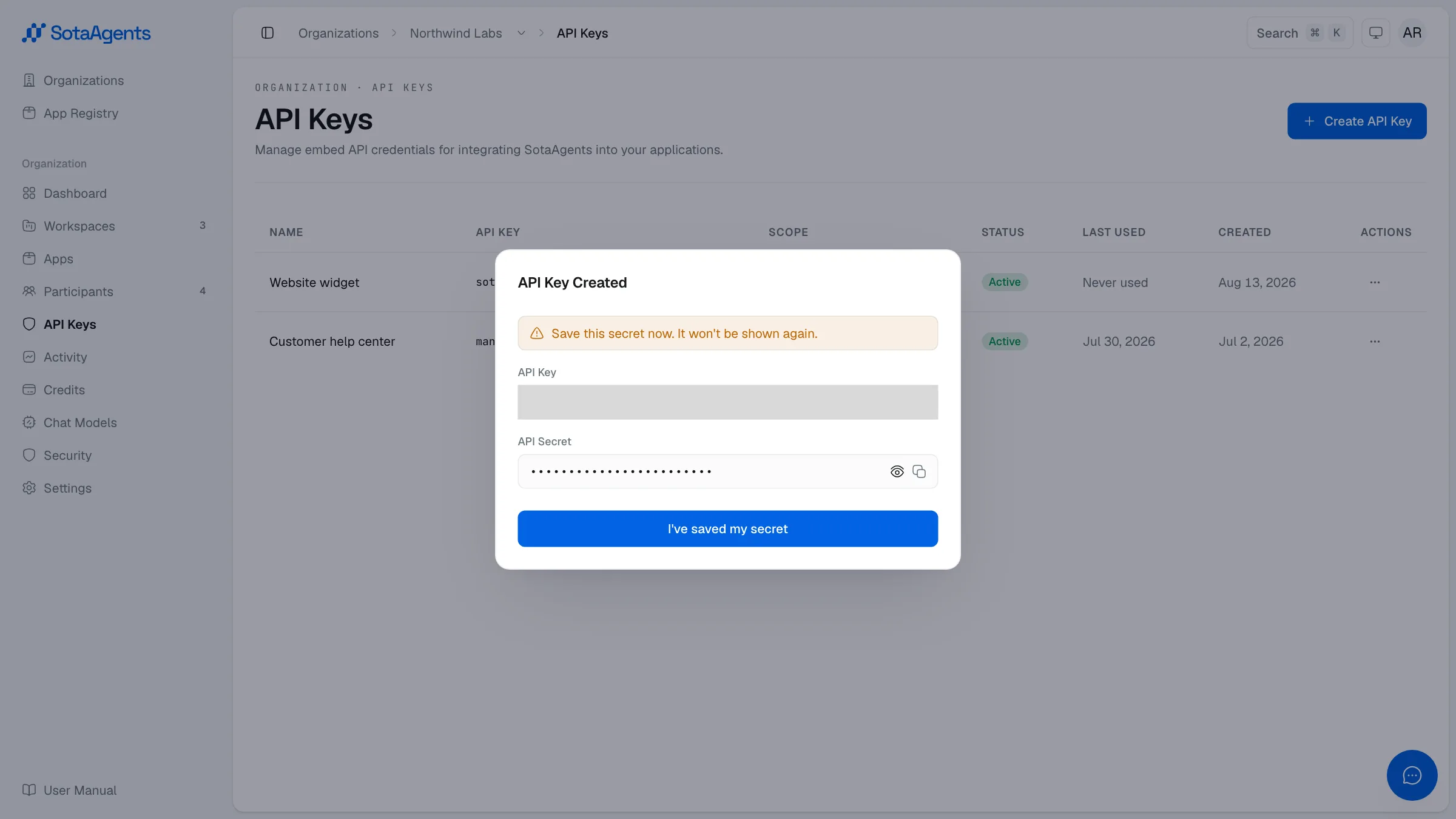 The dialog shown once after creation, with the API key, the masked secret, and a warning that the secret will not be shown again
